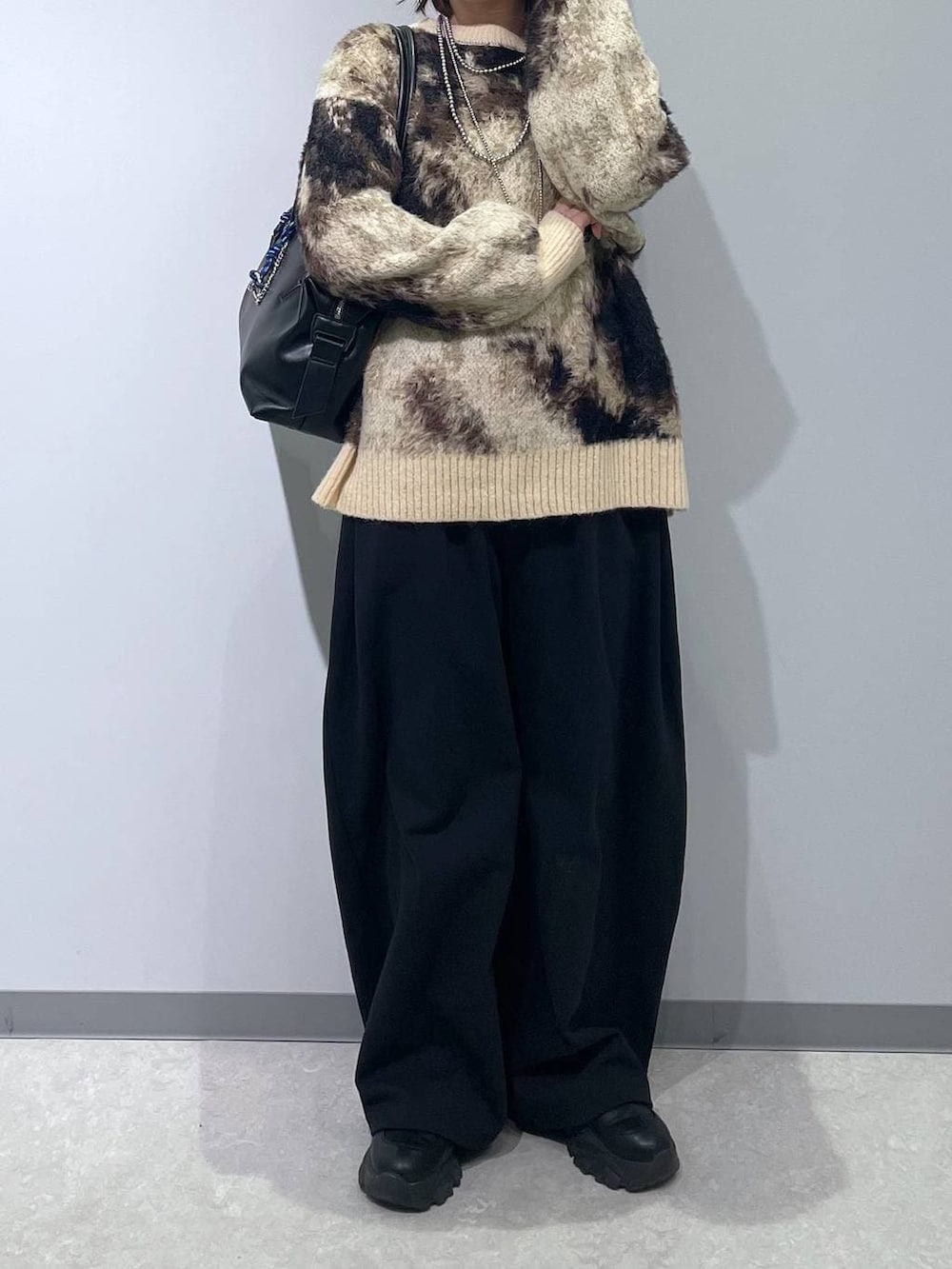 ブラウン系のニット/セーター、ブラック系のボストンバッグ、ブラック系のスウェットパンツを着用したレディースの冬コーディネートの4枚目の写真