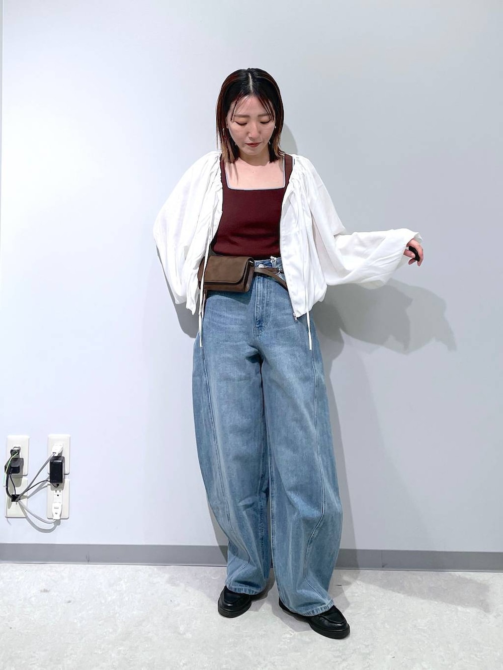 ブルー系のデニムパンツ、ブラウン系のボディバッグ/ウエストポーチ、ブラウン系のタンクトップを着用したレディースの春コーディネートの3枚目の写真