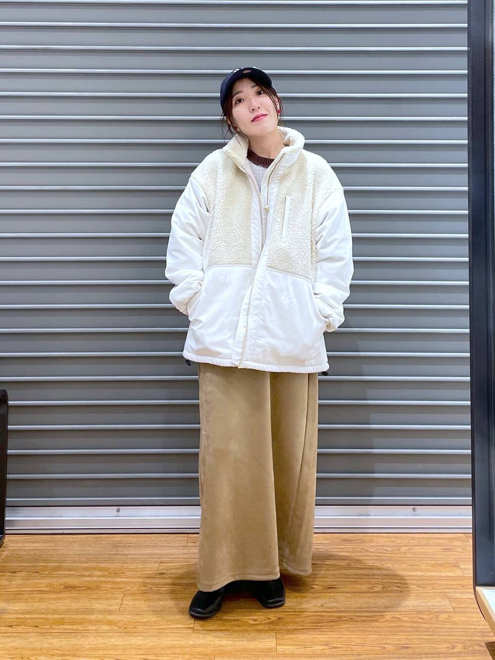 ホワイト系のその他アウター、ベージュ系のスカート、ブラウン系のニット/セーターを着用したレディースの秋コーディネートの2枚目の写真