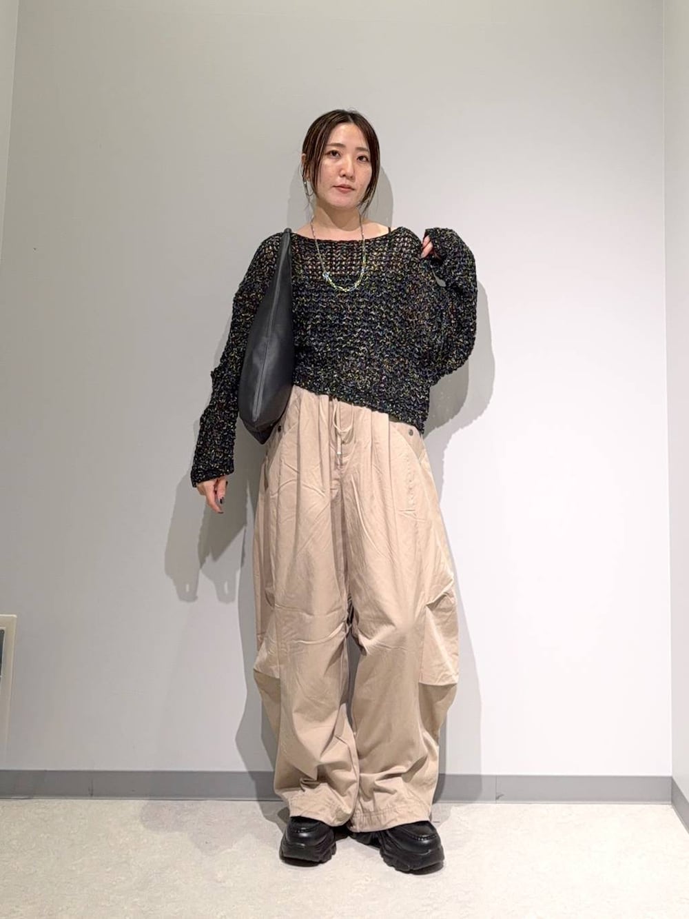 ブラック系のニット/セーター、ブラック系のトートバッグ、ブラック系のローファーを着用したレディースの夏コーディネートの3枚目の写真