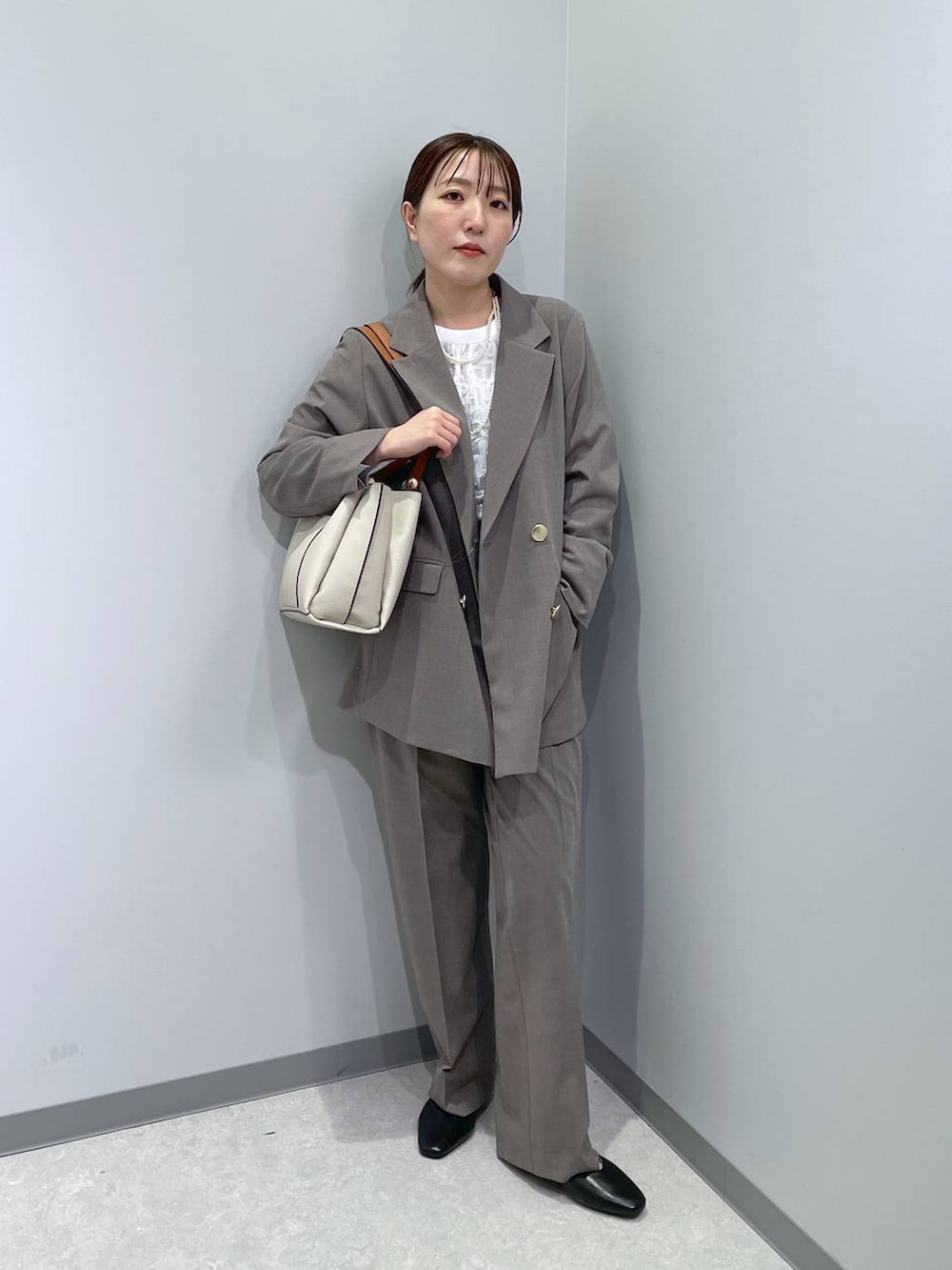 ブラック系のパンプス、ブラウン系のスラックス、ホワイト系のシャツ/ブラウスを着用したレディースの冬コーディネートの3枚目の写真