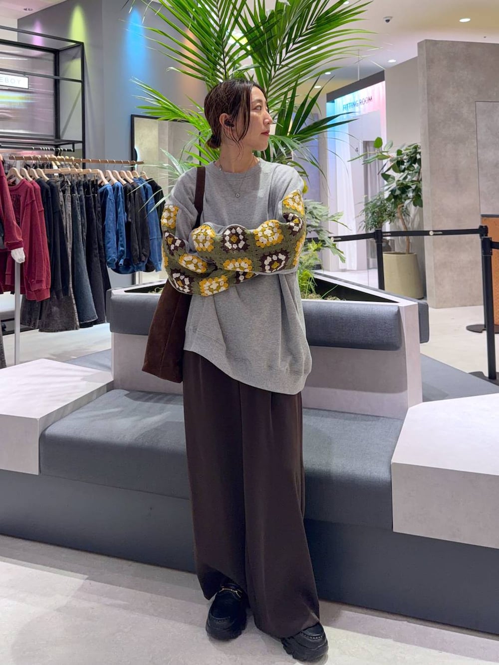 ブラウン系のショルダーバッグ、グレー系のスウェット、ブラウン系のスラックスを着用したレディースの秋コーディネートの2枚目の写真