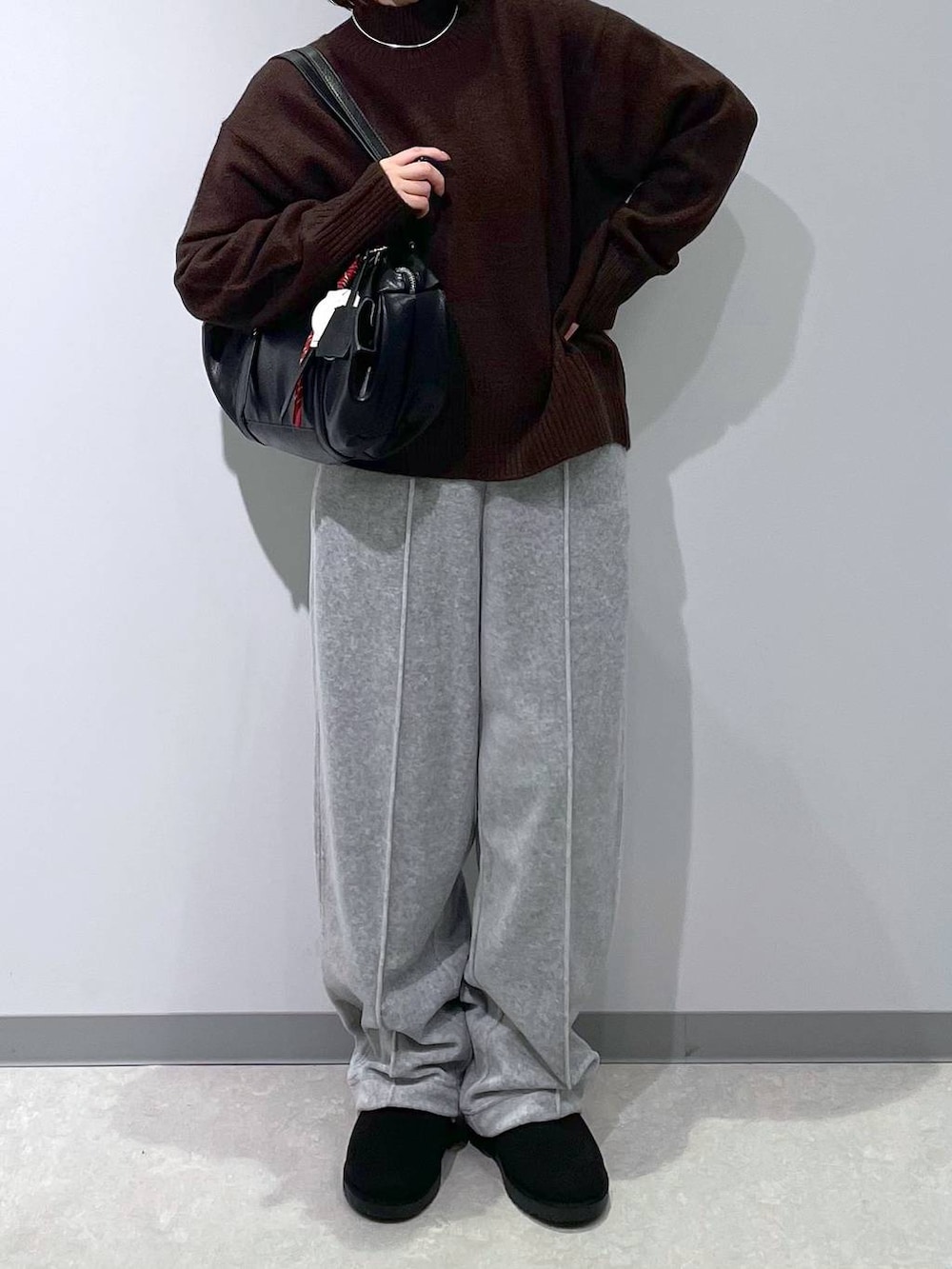 グレー系のその他パンツ、ブラウン系のニット/セーター、ブラック系のブーツを着用したレディースの冬コーディネートの2枚目の写真