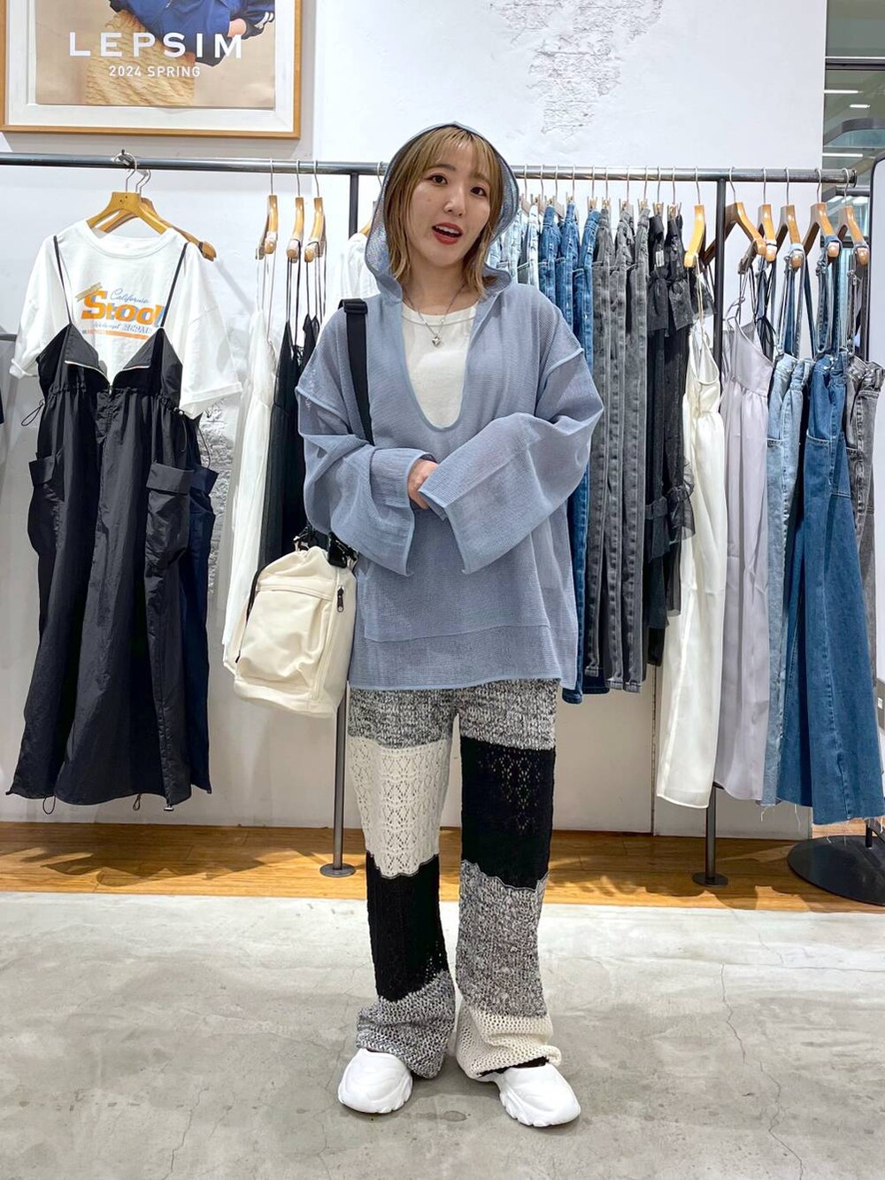 グレー系のその他パンツ、ホワイト系のタンクトップ、ブルー系のパーカーを着用したレディースの春コーディネートの3枚目の写真