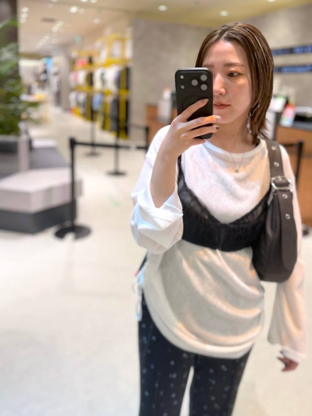 ブラック系のキャミソール、ブラック系のショルダーバッグ、ホワイト系のTシャツ/カットソーを着用したレディースの夏コーディネートの3枚目の写真