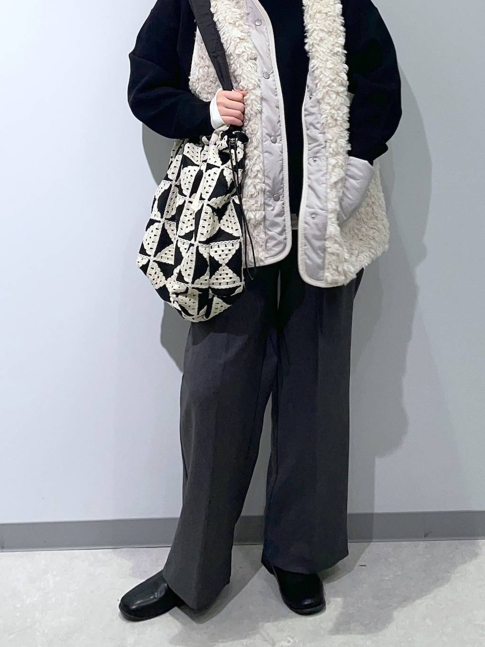 ホワイト系のTシャツ/カットソー、ベージュ系のベスト、ブラック系のスウェットを着用したレディースの秋コーディネートの2枚目の写真