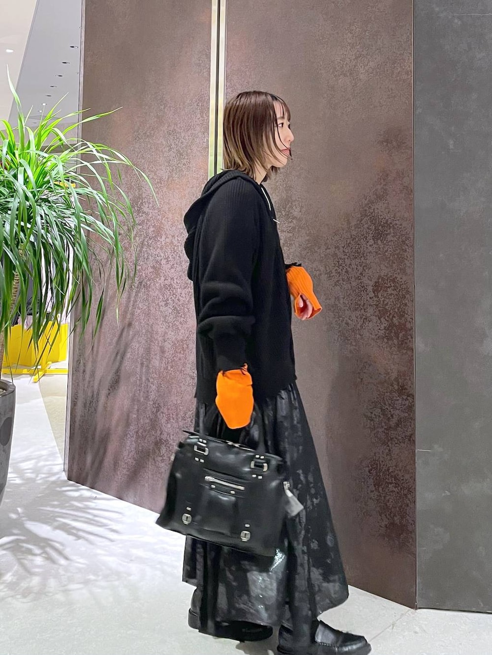 ブラック系のボストンバッグ、ホワイト系のニット/セーター、ブラック系のパーカーを着用したレディースの秋コーディネートの2枚目の写真