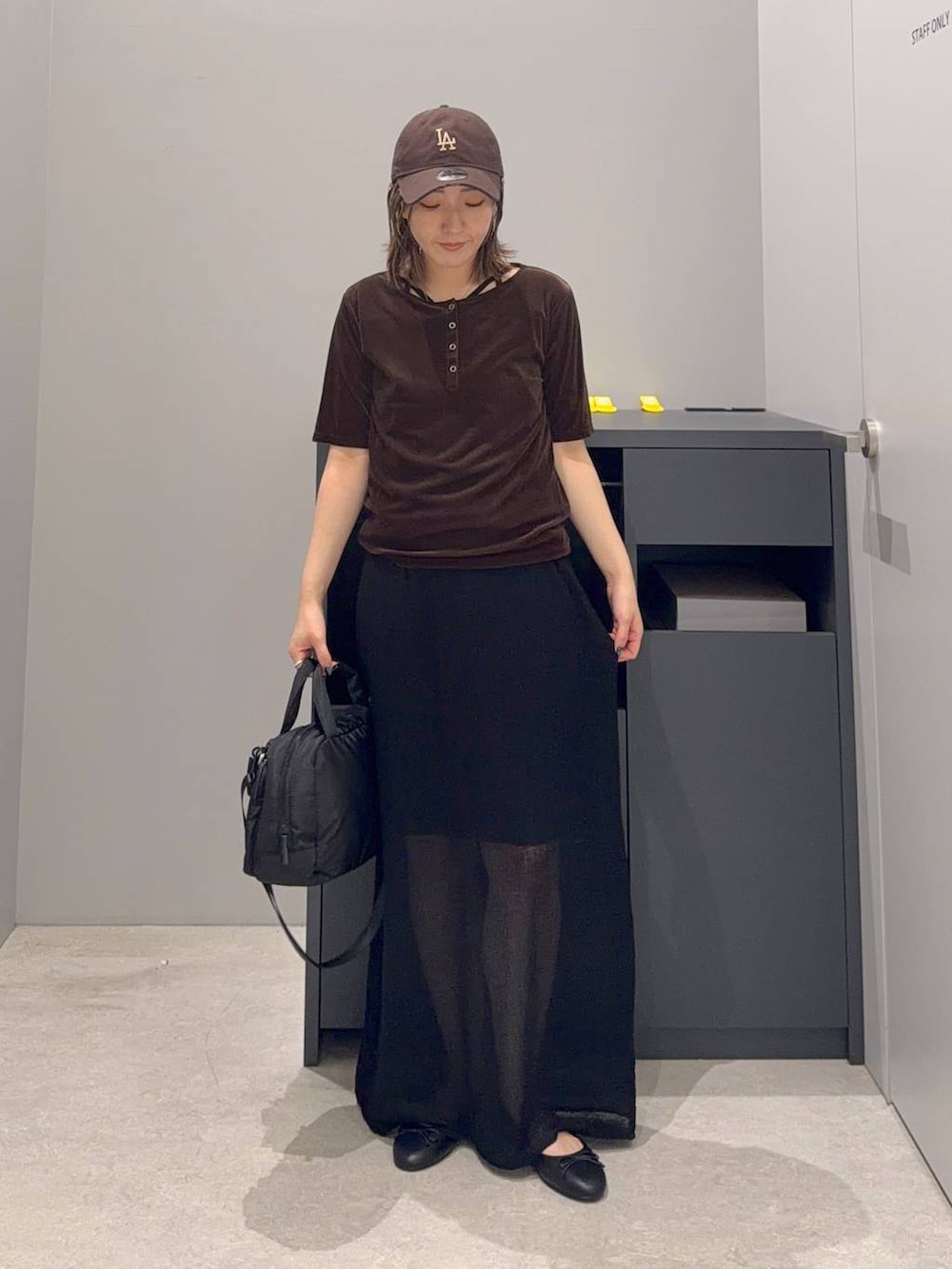 ブラック系のバレエシューズ、ブラック系のスカート、ブラック系のボストンバッグを着用したレディースの夏コーディネートの2枚目の写真