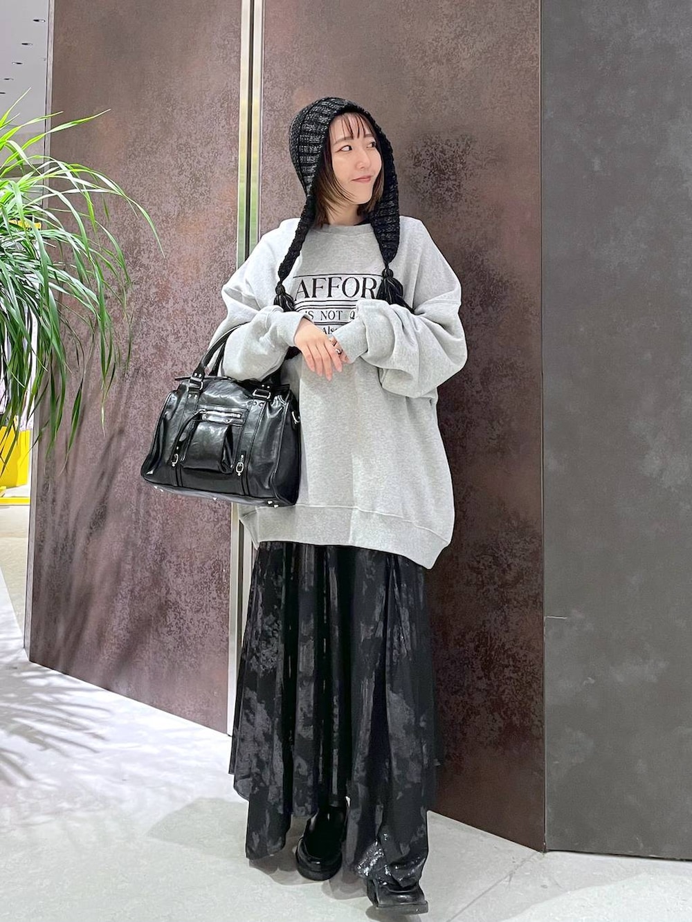 ブラック系のボストンバッグ、グレー系のスウェット、ブラック系のスカートを着用したレディースの秋コーディネートの4枚目の写真
