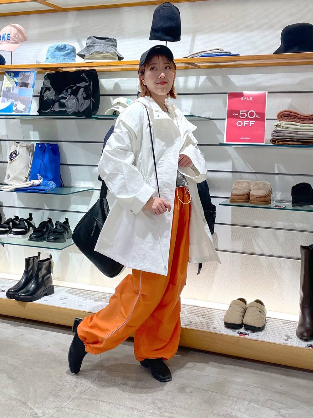 オレンジ系のその他パンツ、ホワイト系のその他アウター、グレー系のTシャツ/カットソーを着用したレディースの春コーディネートの4枚目の写真