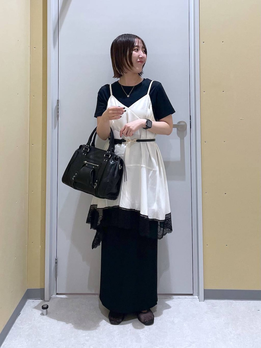 ブラック系のスカート、ブラック系のボストンバッグ、ブラック系のTシャツ/カットソーを着用したレディースの夏コーディネートの3枚目の写真