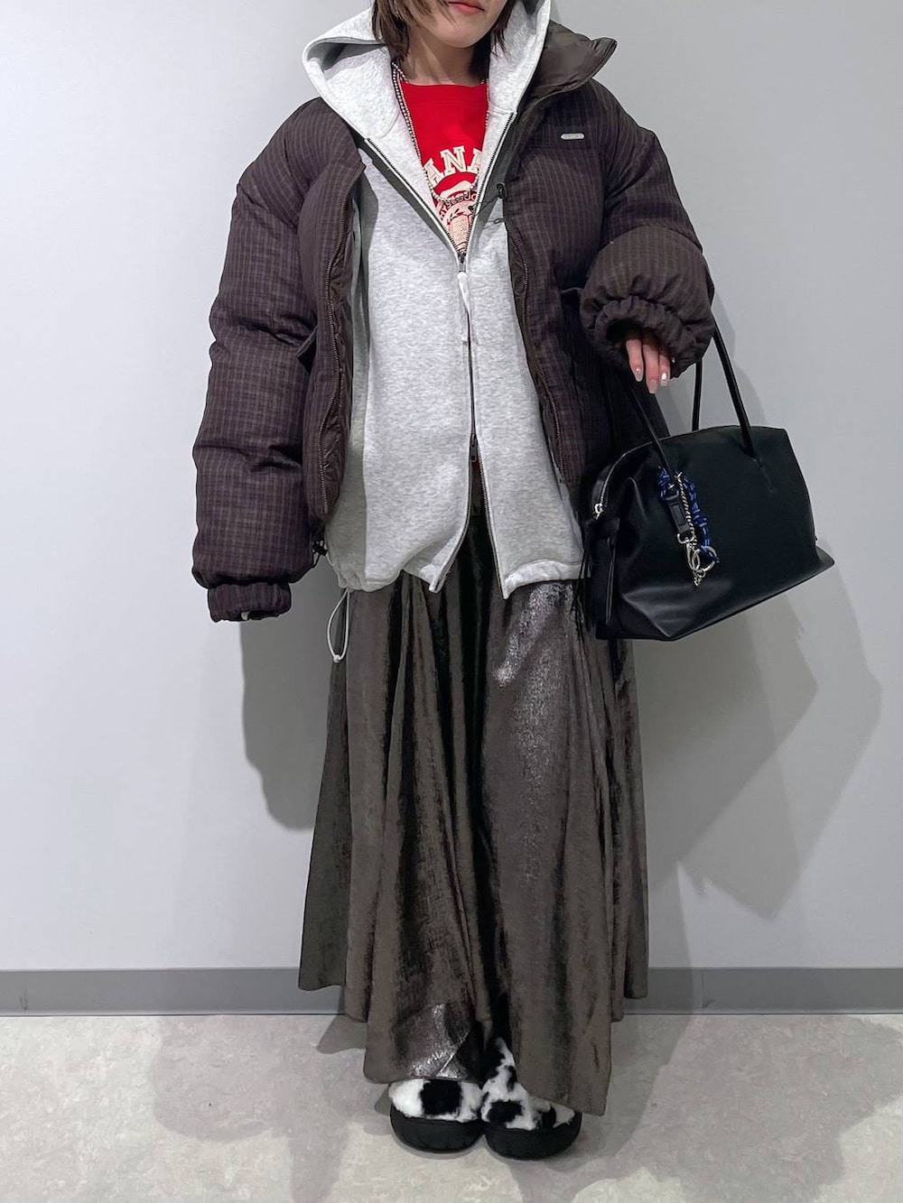 ホワイト系のスリッポン、ブラック系のボストンバッグ、ブラウン系のブルゾンを着用したレディースの冬コーディネートの3枚目の写真