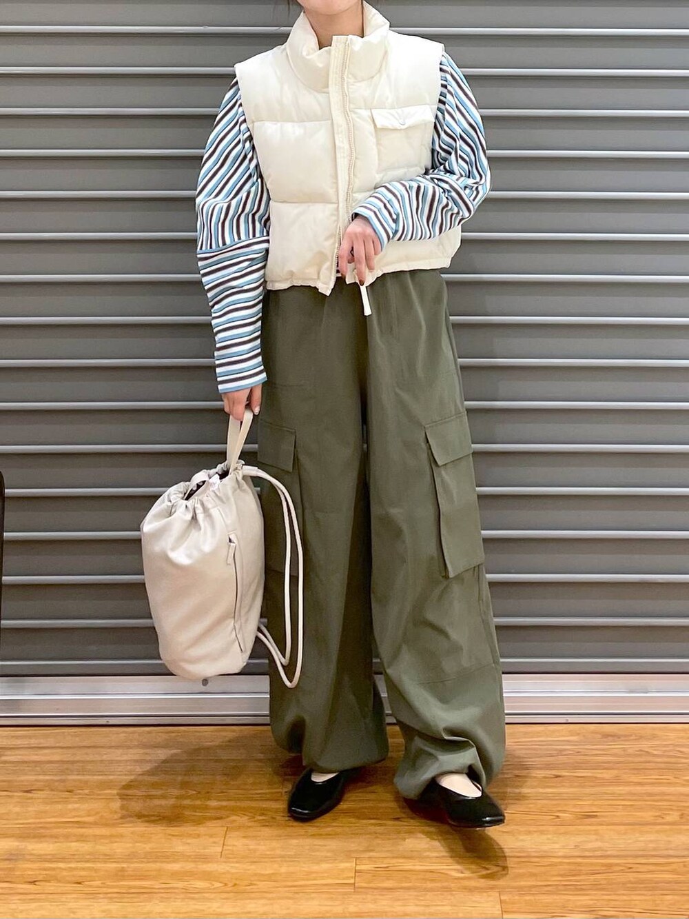 ベージュ系のショルダーバッグ、ブラック系のパンプス、ブルー系のTシャツ/カットソーを着用したレディースの春コーディネートの2枚目の写真