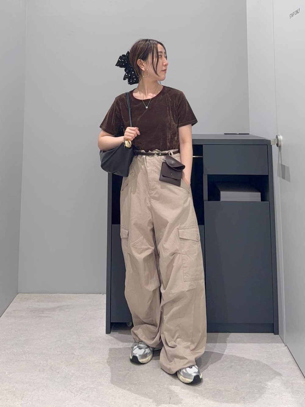 ベージュ系のカーゴパンツ、ブラウン系のTシャツ/カットソー、ブラック系のショルダーバッグを着用したレディースの夏コーディネートの2枚目の写真