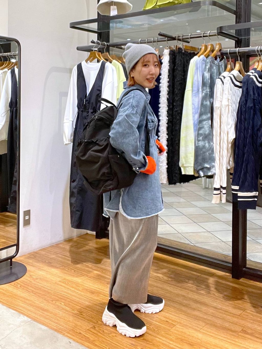 グレー系のスカート、ブラック系のバックパック/リュック、ブルー系のシャツ/ブラウスを着用したレディースの冬コーディネートの5枚目の写真