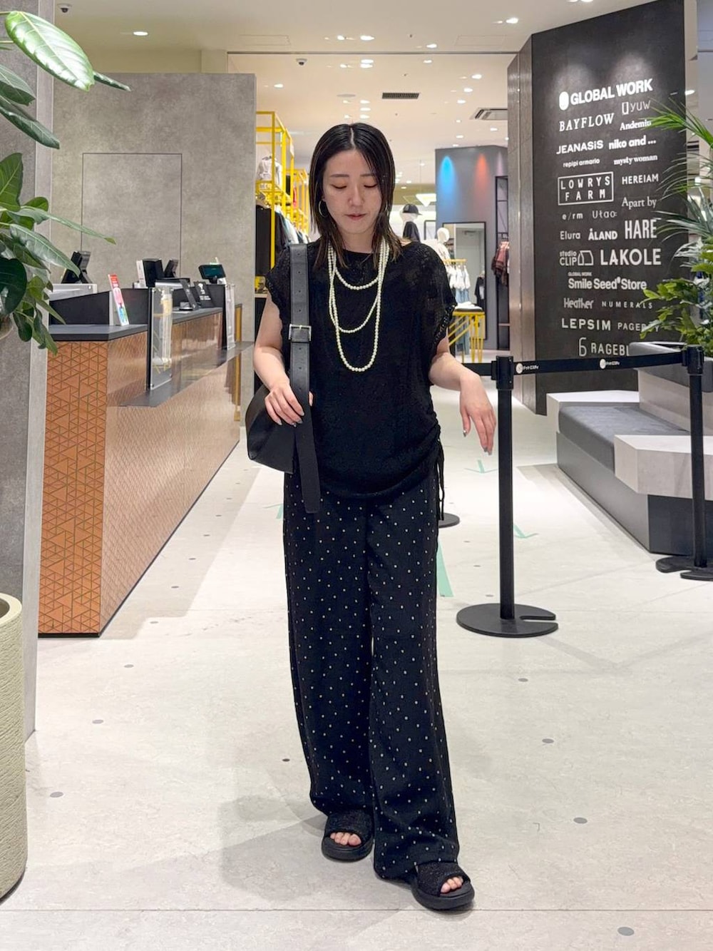 グレー系のその他パンツ、ブラック系のショルダーバッグ、ブラック系のサンダルを着用したレディースの夏コーディネートの2枚目の写真