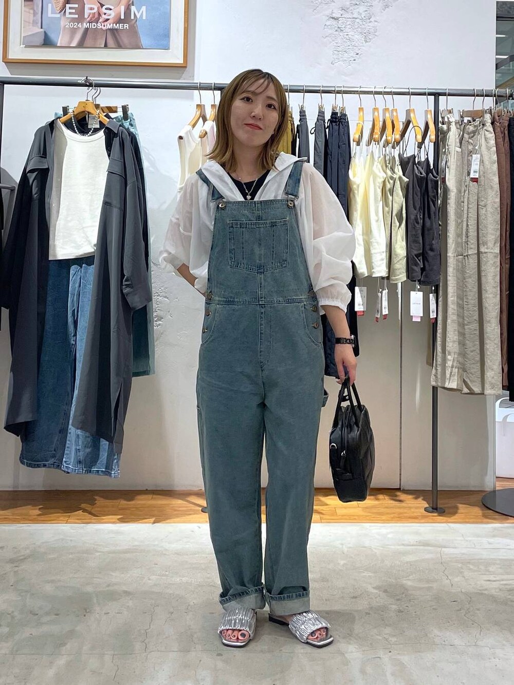 ブラック系のタンクトップ、ブルー系のサロペット/オーバーオール、シルバー系のサンダルを着用したレディースの秋コーディネートの3枚目の写真