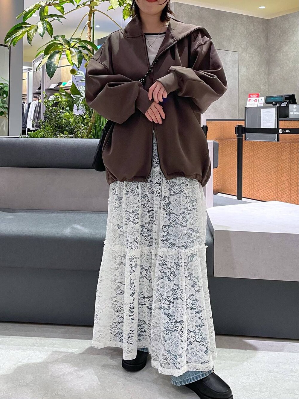 ブラック系のローファー、ブルー系のデニムパンツ、ホワイト系のスカートを着用したレディースの秋コーディネートの2枚目の写真