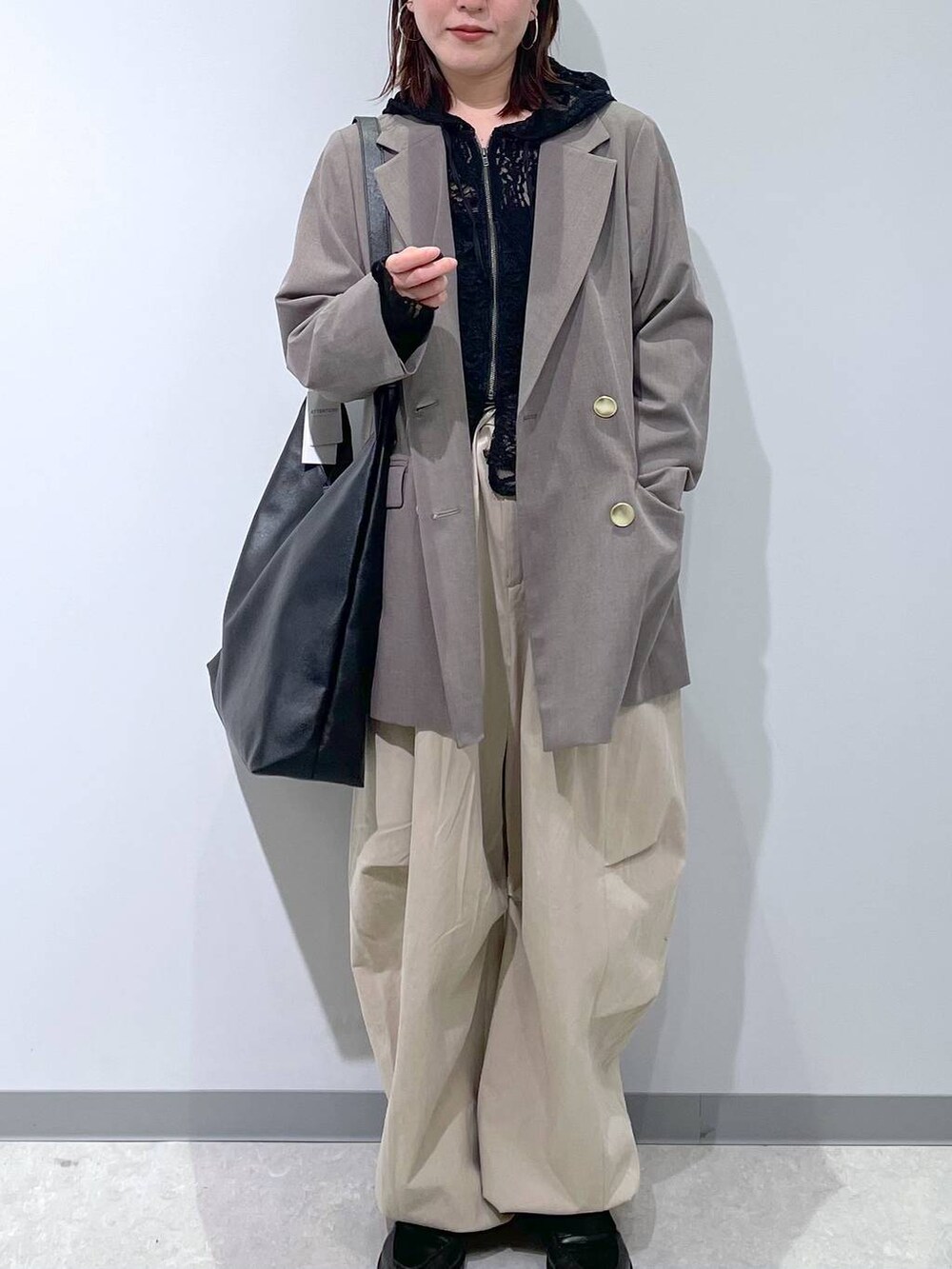 ブラック系のショルダーバッグ、ブラウン系のテーラードジャケット、ブラック系のパーカーを着用したレディースの春コーディネートの2枚目の写真