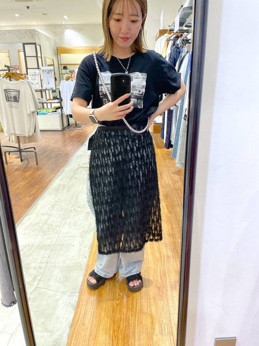ブラック系のTシャツ/カットソー、ブルー系のデニムパンツ、ブラック系のスカートを着用したレディースの夏コーディネートの2枚目の写真