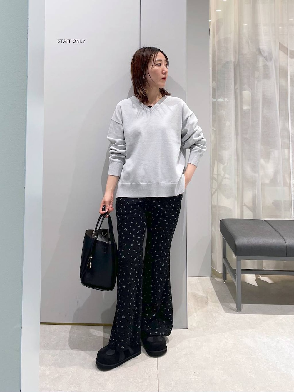 ブラック系のトートバッグ、グレー系のニット/セーター、ブラック系のその他パンツを着用したレディースの春コーディネートの2枚目の写真