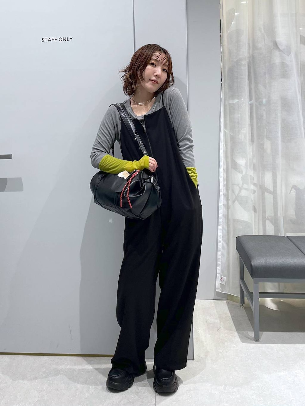 ブラック系のボストンバッグ、ブラック系のローファー、ブラック系のサロペット/オーバーオールを着用したレディースの冬コーディネートの5枚目の写真