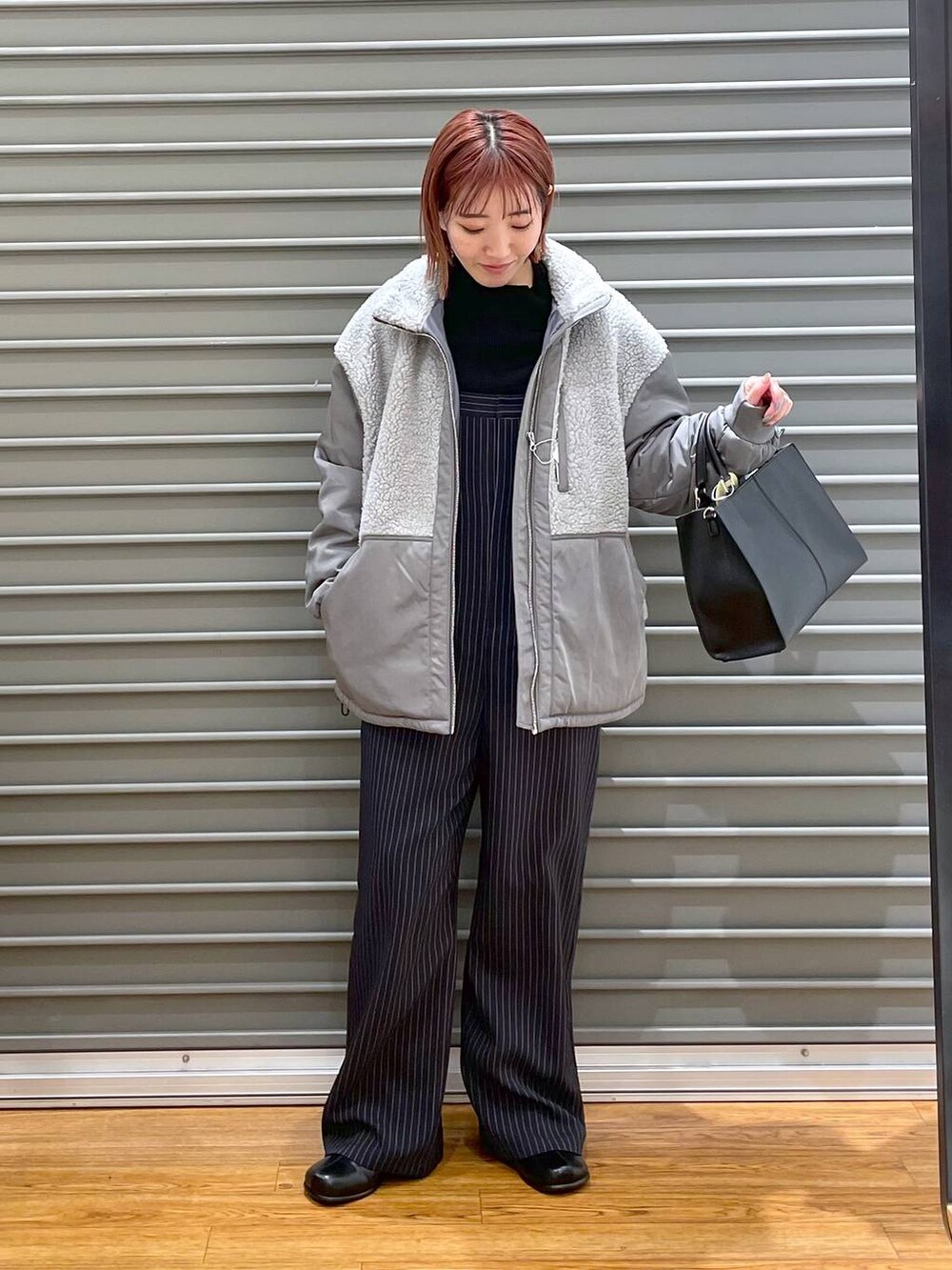 ブラック系のニット/セーター、グレー系のその他アウター、ブラック系のショルダーバッグを着用したレディースの冬コーディネートの3枚目の写真