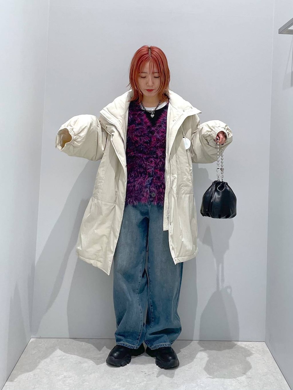 ホワイト系のその他アウター、ブラック系のショルダーバッグ、ブルー系のデニムパンツを着用したレディースの秋コーディネートの2枚目の写真