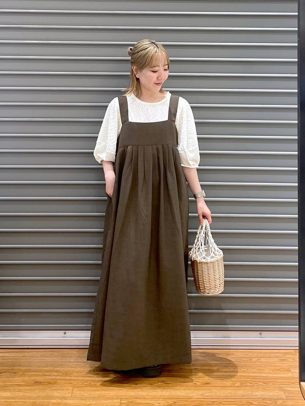 ホワイト系のかごバッグ、ホワイト系のTシャツ/カットソー、グリーン系のワンピースを着用したレディースの春コーディネートの2枚目の写真