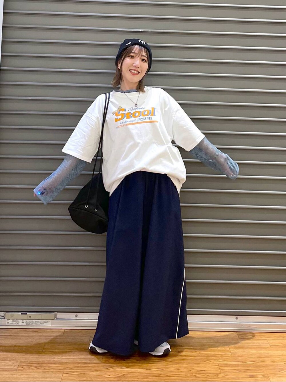 グレー系のスニーカー、ブラック系のショルダーバッグ、ブルー系のその他パンツを着用したレディースの春コーディネートの3枚目の写真