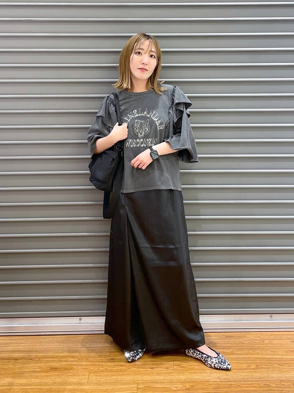 ブラック系のショルダーバッグ、シルバー系のパンプス、ブラック系のスカートを着用したレディースの夏コーディネートの3枚目の写真