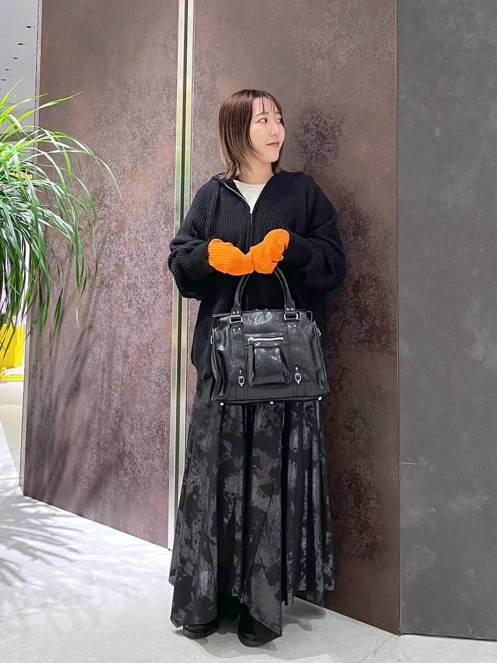 ブラック系のボストンバッグ、ホワイト系のニット/セーター、ブラック系のパーカーを着用したレディースの秋コーディネートの3枚目の写真