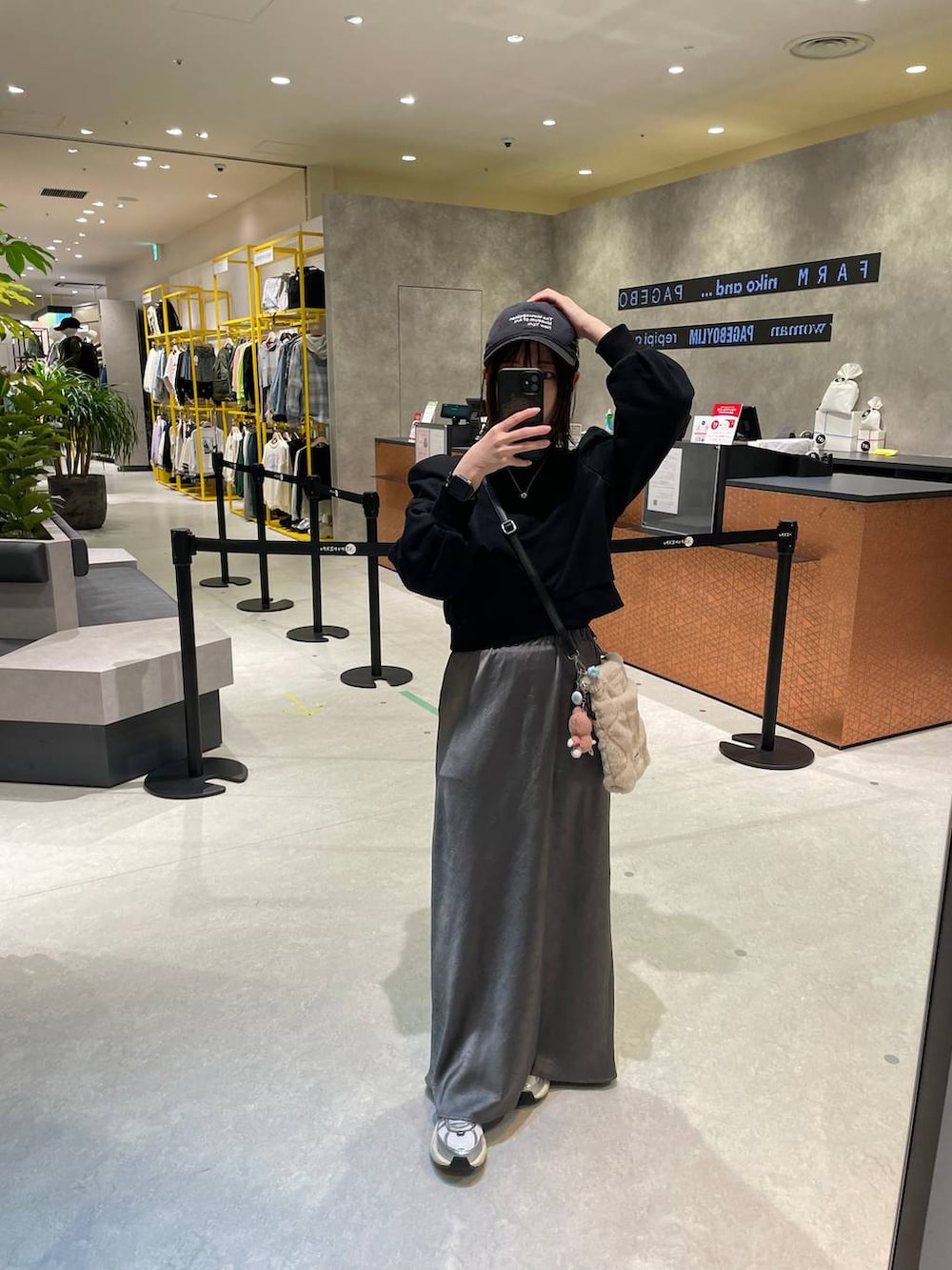 グレー系のスカート、ブラック系のスウェットを着用したレディースの秋コーディネートの3枚目の写真