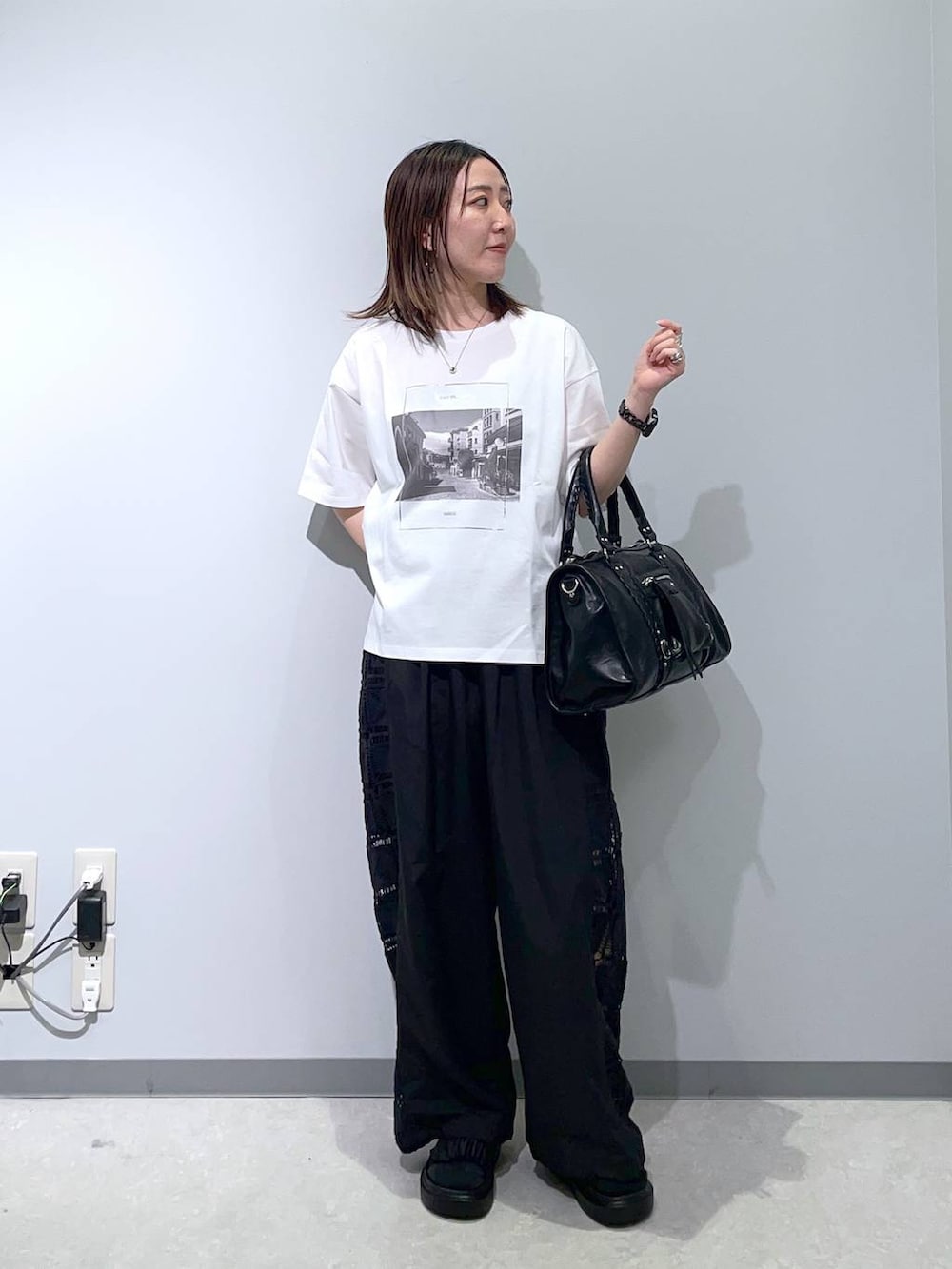 ホワイト系のTシャツ/カットソー、ブラック系のその他パンツ、ブラック系のサンダルを着用したレディースの春コーディネートの2枚目の写真