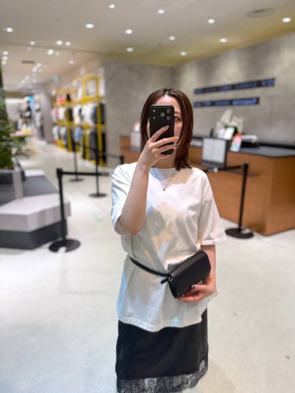 ブラック系のボディバッグ/ウエストポーチ、ホワイト系のTシャツ/カットソー、ブラック系のスカートを着用したレディースの夏コーディネートの4枚目の写真