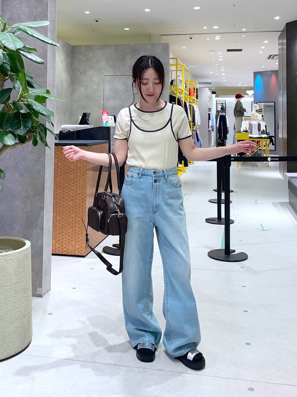 ブラウン系のボストンバッグ、シルバー系のサンダル、ベージュ系のTシャツ/カットソーを着用したレディースの春コーディネートの3枚目の写真