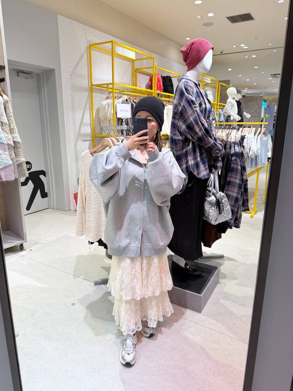 ホワイト系のスカート、グレー系のパーカーを着用したレディースの秋コーディネートの2枚目の写真