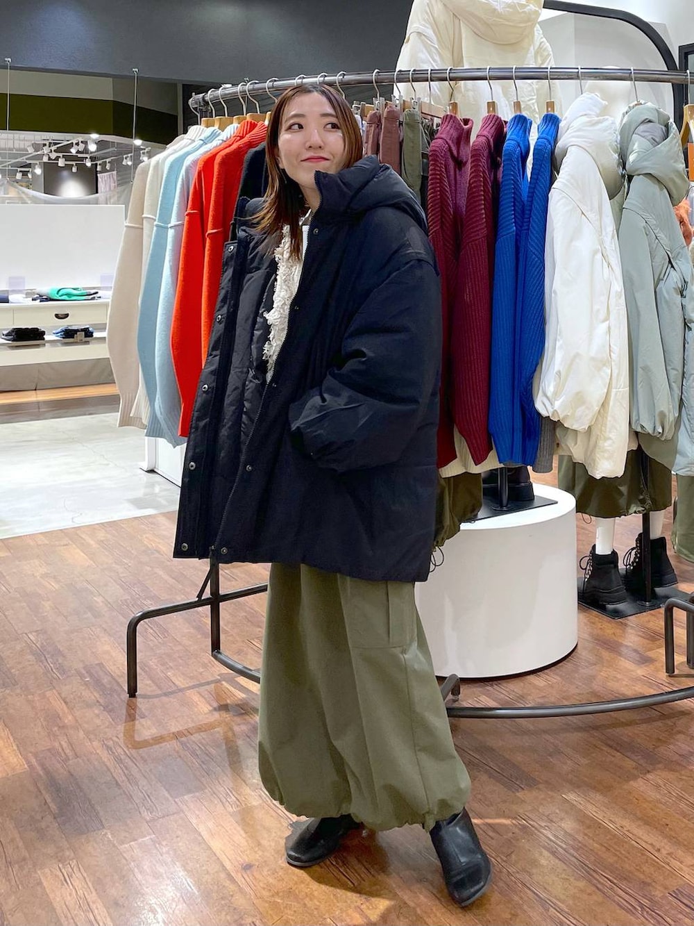 ホワイト系のTシャツ/カットソー、ブラック系のその他アウター、グリーン系のスカートを着用したレディースの冬コーディネートの2枚目の写真