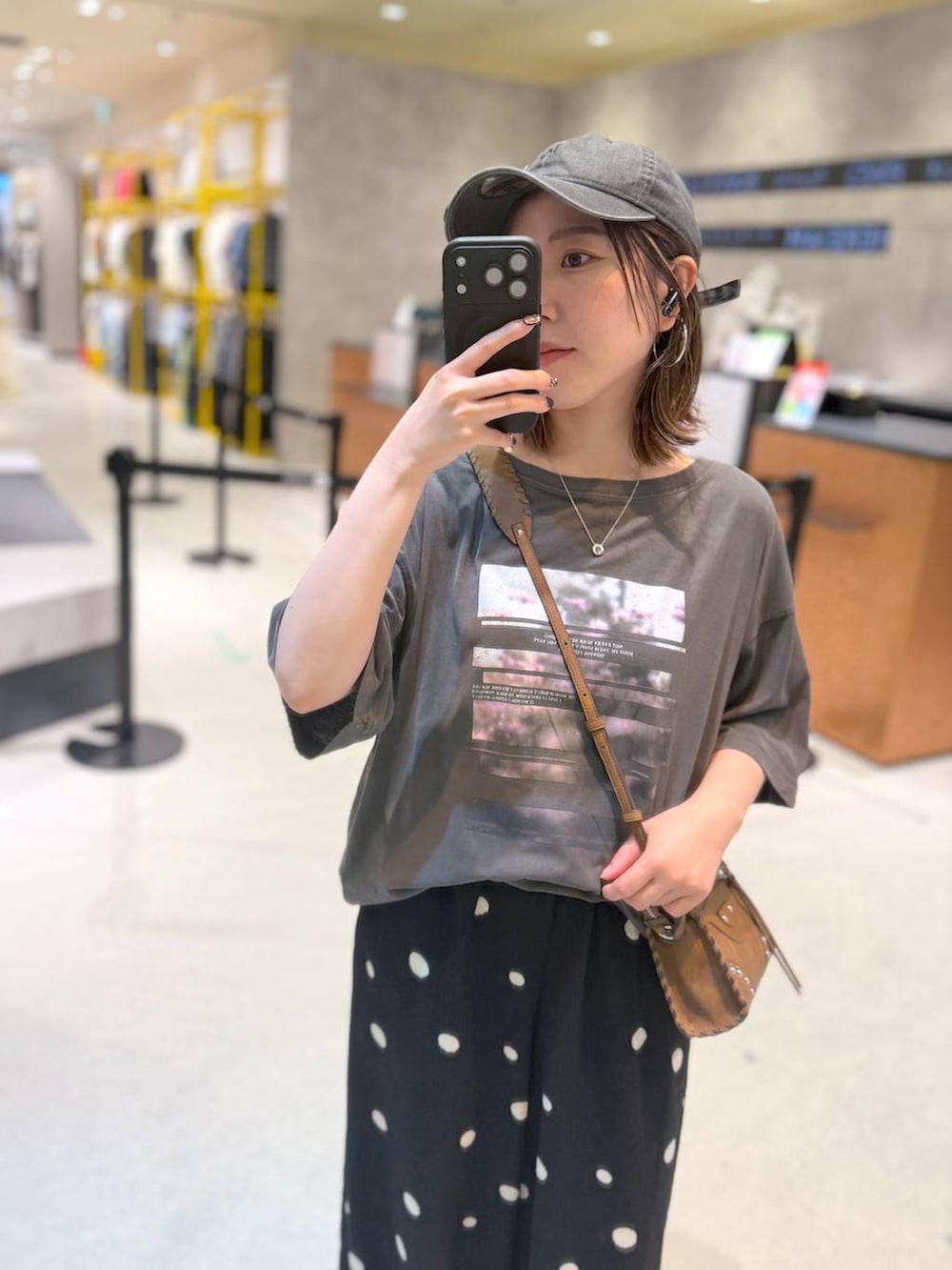 ブラック系のその他パンツ、グレー系のTシャツ/カットソー、ブラウン系のショルダーバッグを着用したレディースの夏コーディネートの2枚目の写真
