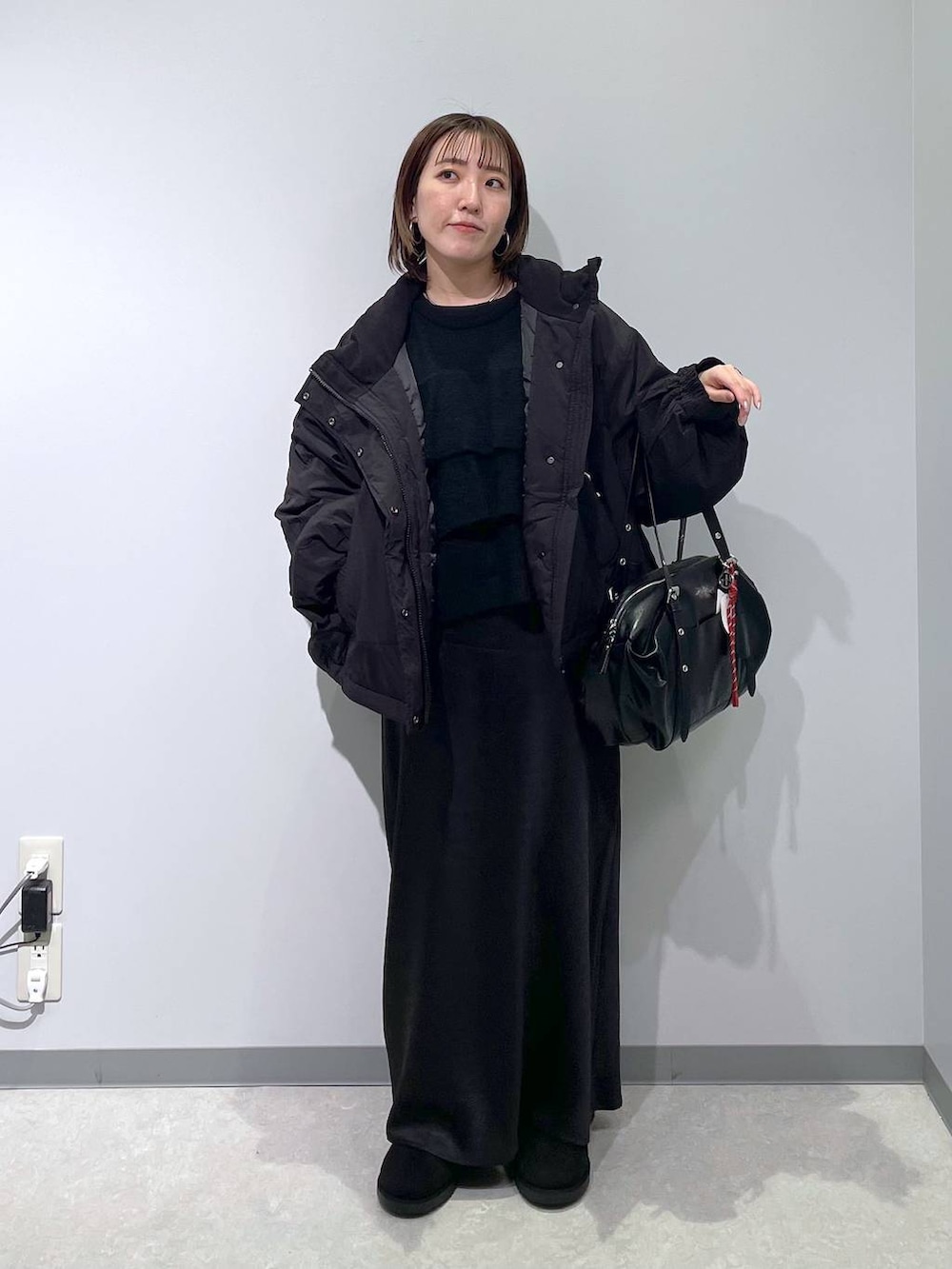 ブラック系のその他アウター、ブラック系のスカート、ブラック系のブーツを着用したレディースの冬コーディネートの3枚目の写真