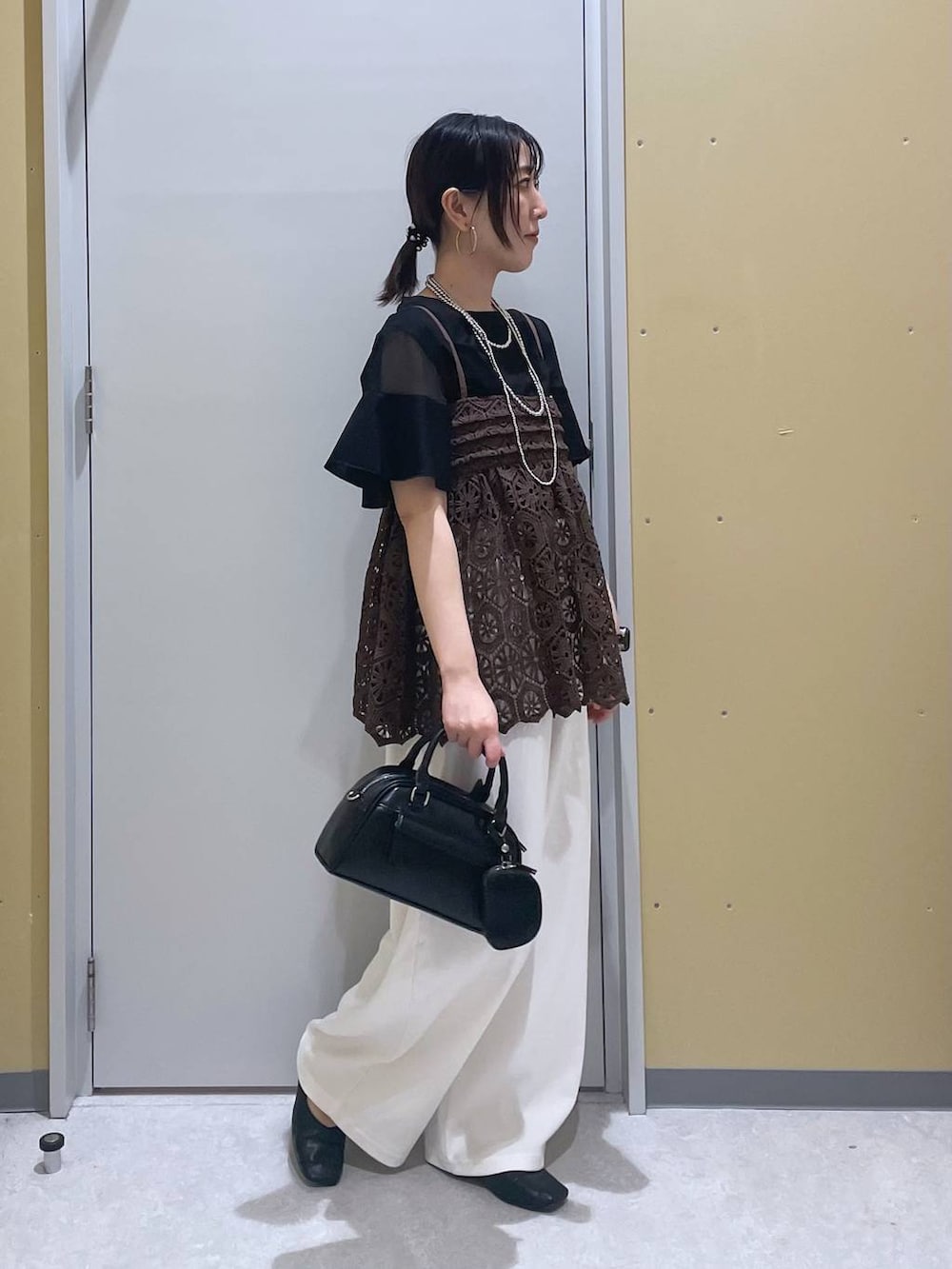 ブラック系のTシャツ/カットソー、ブラウン系のキャミソール、ブラック系のショルダーバッグを着用したレディースの夏コーディネートの2枚目の写真