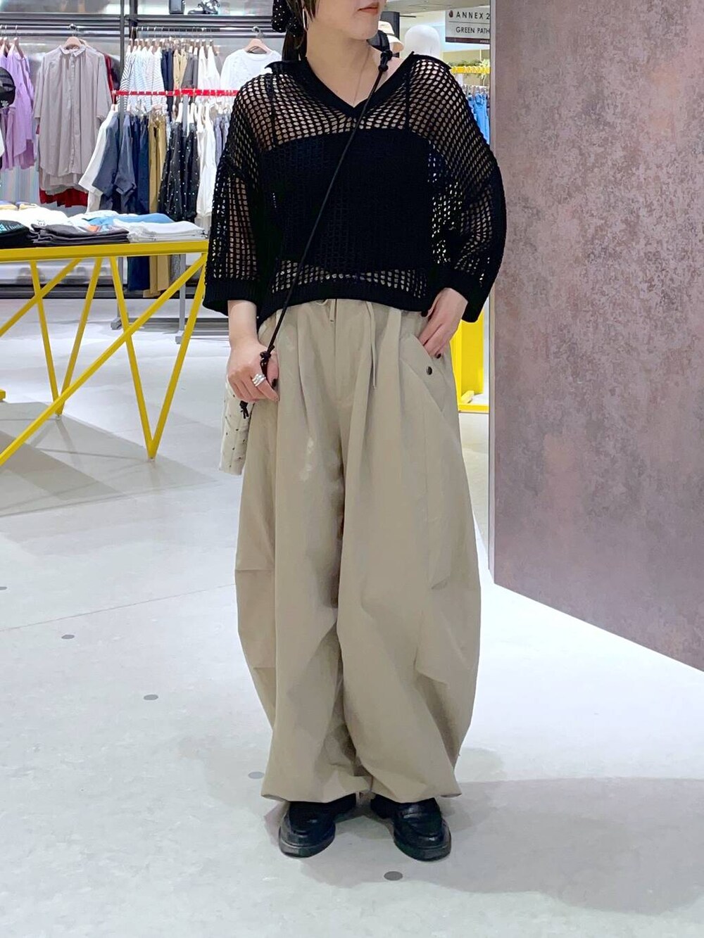 ホワイト系のショルダーバッグ、ブラック系のニット/セーター、ベージュ系のその他パンツを着用したレディースの夏コーディネートの2枚目の写真