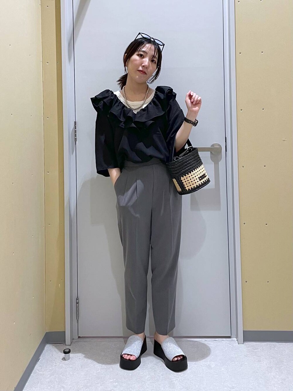 シルバー系のサンダル、ブラック系のショルダーバッグ、グレー系のその他パンツを着用したレディースの夏コーディネートの3枚目の写真