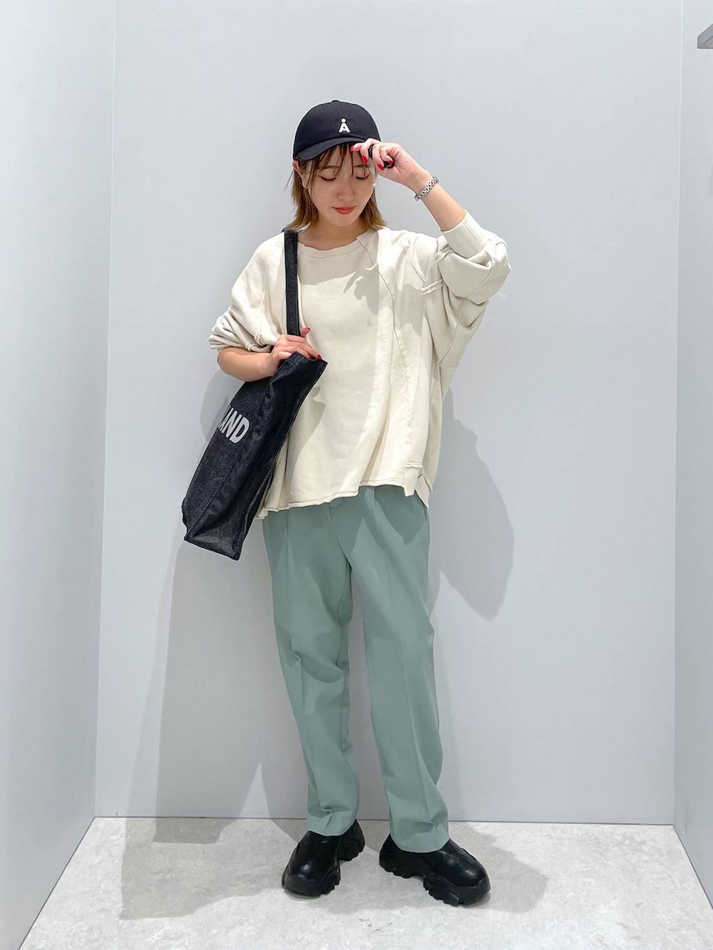 ブラック系のトートバッグ、グリーン系のその他パンツ、ベージュ系のTシャツ/カットソーを着用したレディースの秋コーディネートの4枚目の写真