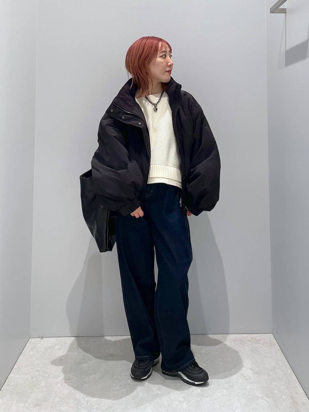 ブラック系のショルダーバッグ、ホワイト系のニット/セーター、ブラック系のその他アウターを着用したレディースの秋コーディネートの2枚目の写真