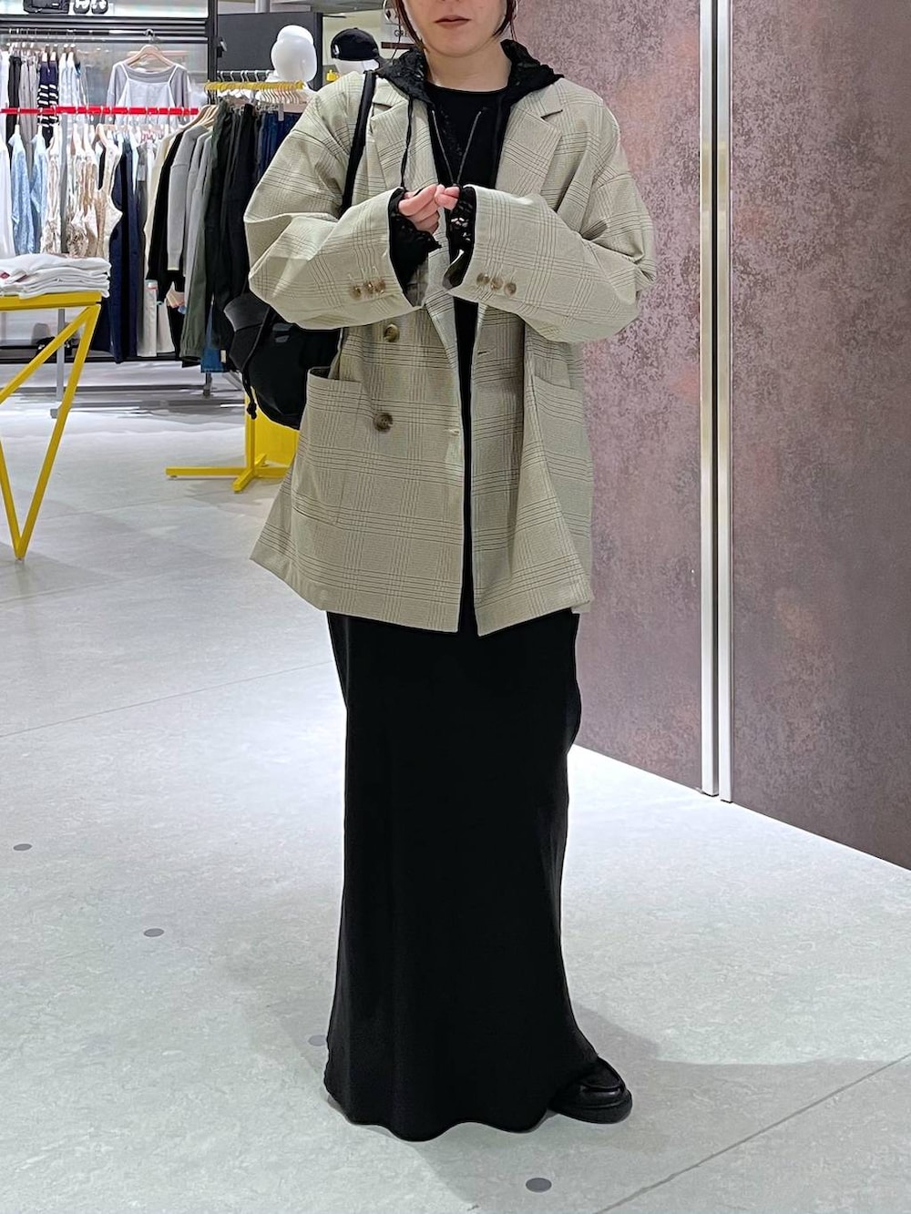 ブラック系のショルダーバッグ、ベージュ系のテーラードジャケット、ブラック系のパーカーを着用したレディースの春コーディネートの2枚目の写真