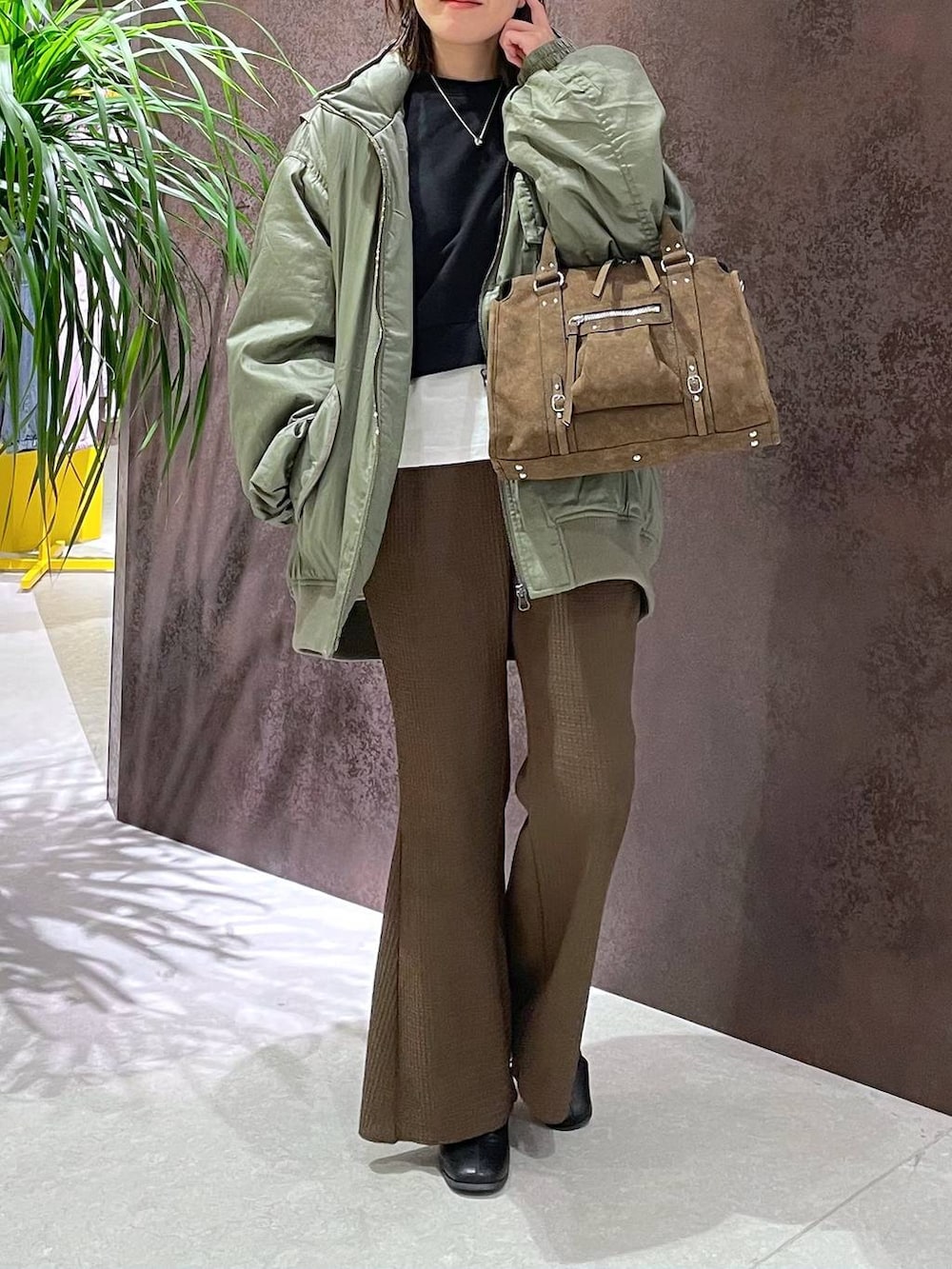 ブラウン系のボストンバッグ、ブラウン系のその他パンツ、グリーン系のブルゾンを着用したレディースの秋コーディネートの3枚目の写真
