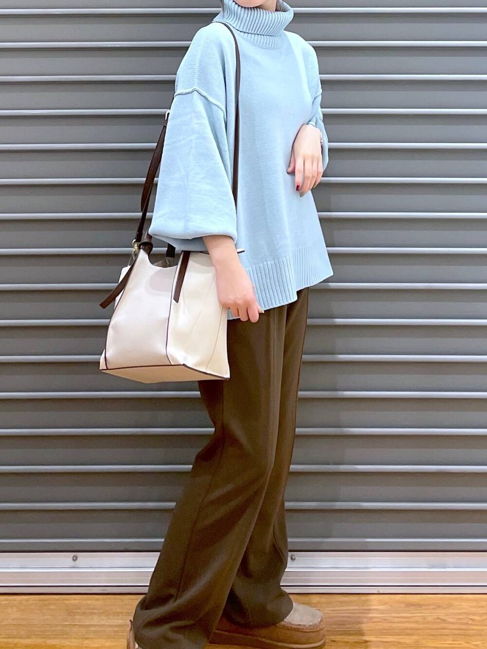 ブルー系のニット/セーター、ブラウン系のその他パンツ、ベージュ系のモカシン/デッキシューズを着用したレディースの冬コーディネートの2枚目の写真