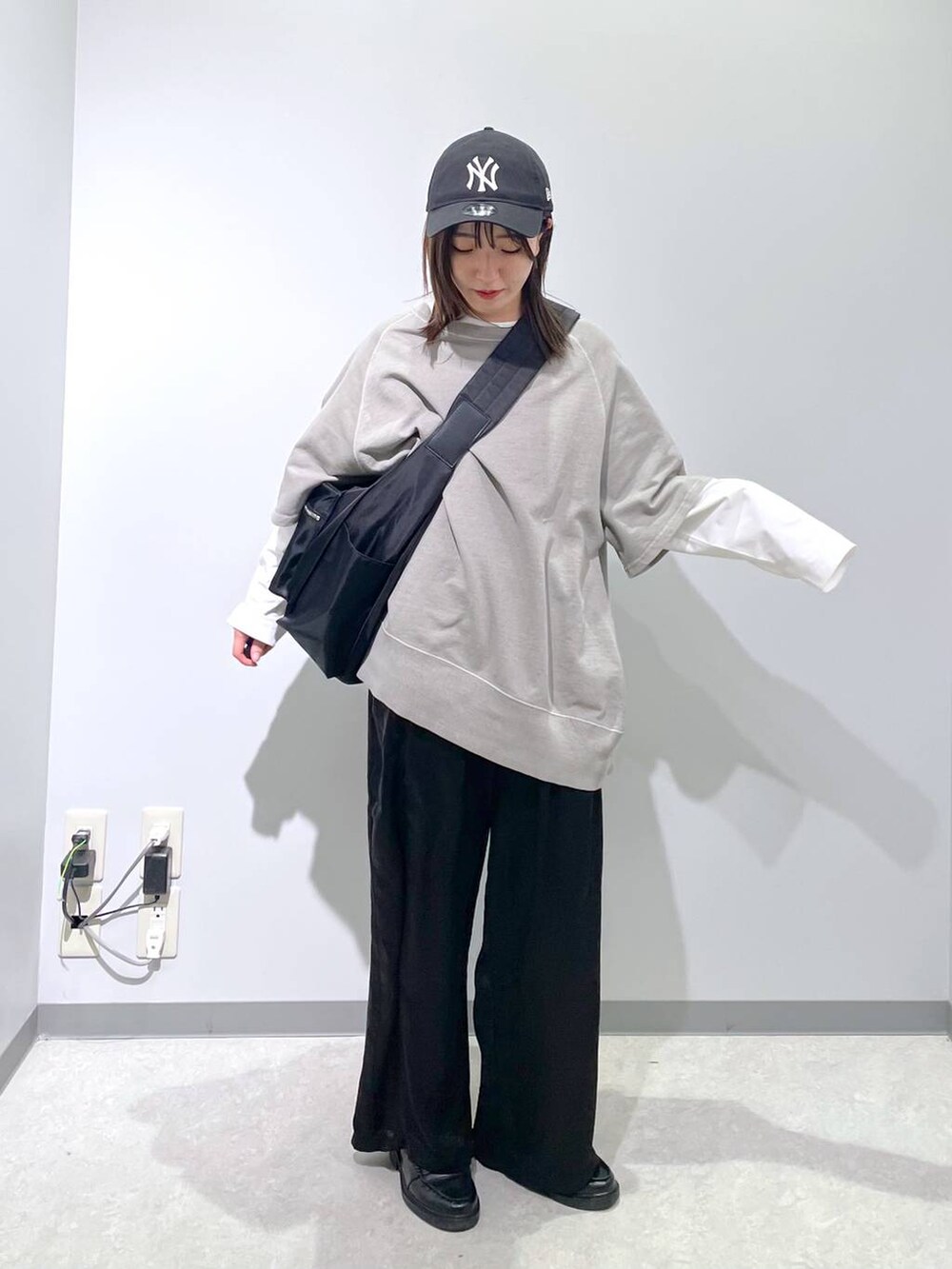 ブラック系のショルダーバッグ、ホワイト系のTシャツ/カットソー、ブラック系のその他パンツを着用したレディースの春コーディネートの4枚目の写真