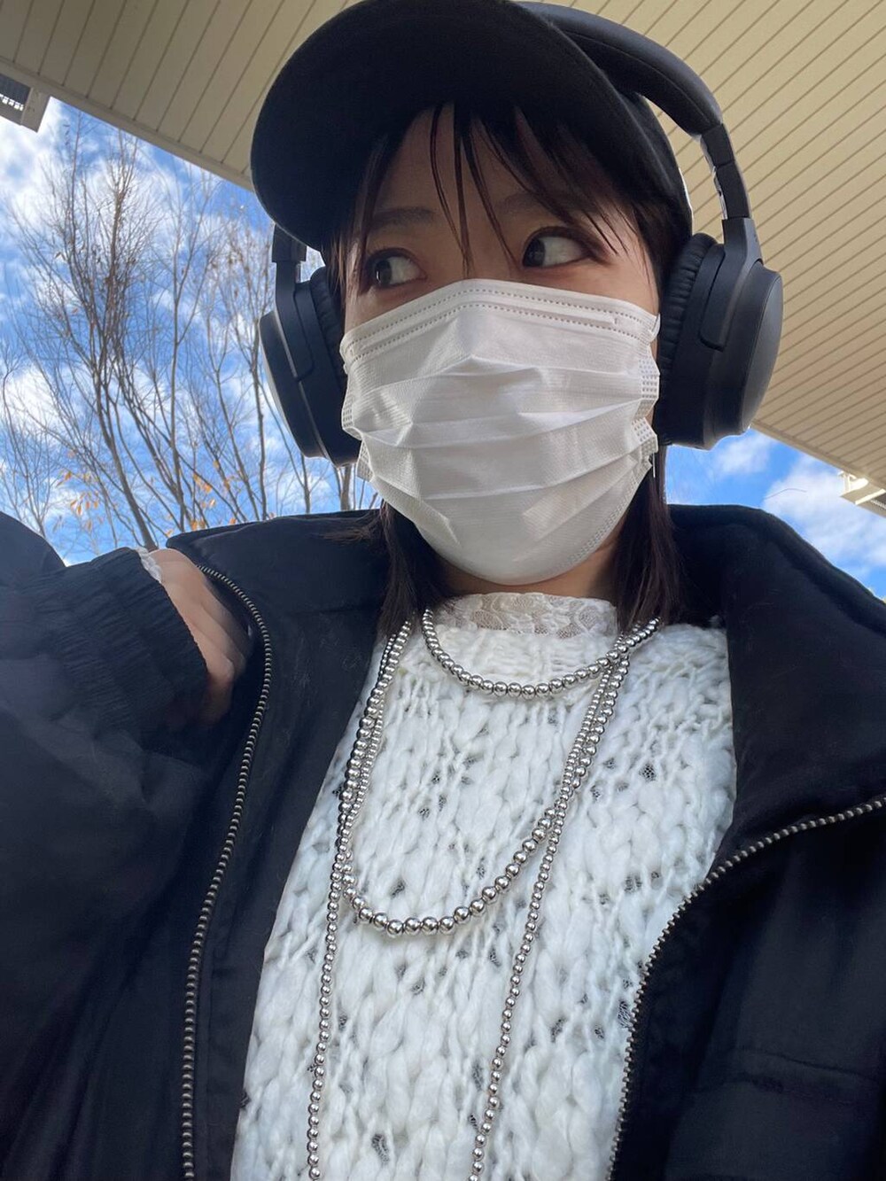 グレー系のスラックス、ブラック系のブルゾン、ホワイト系のニット/セーターを着用したレディースの冬コーディネートの3枚目の写真